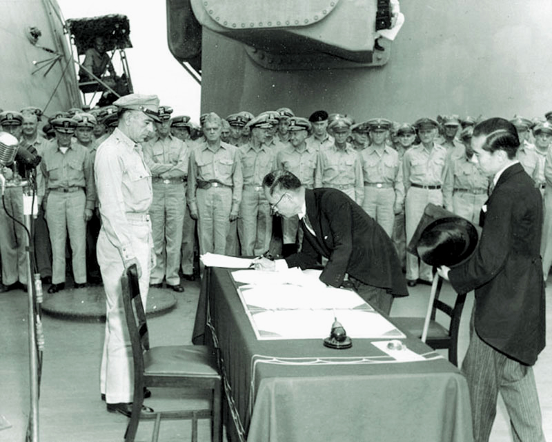 ABOARD USS MISSOURI (BB 63), in Tokyo Bay, September 2, 1945: Lieutenant General Richard Sutherland, left, watches Japan Foreign Affairs Minister Mamoru Shigemitsu sign the Japanese Instrument of Surrender. (U.S. Army Signal Corps photo)